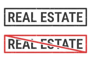 conceptual image with 2 "real estate" rubber stamps with one crossed out - signifying an expired real estate license
