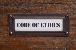 wooden background with a "code of ethics' sign on it